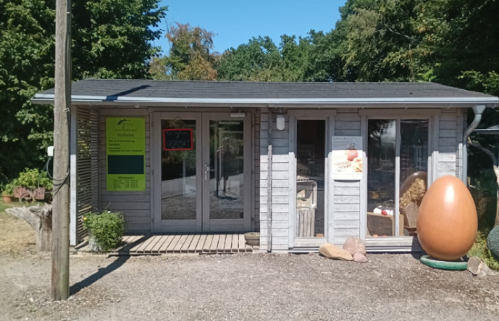 Graue Holzhütte als SB Laden und Deko Ei